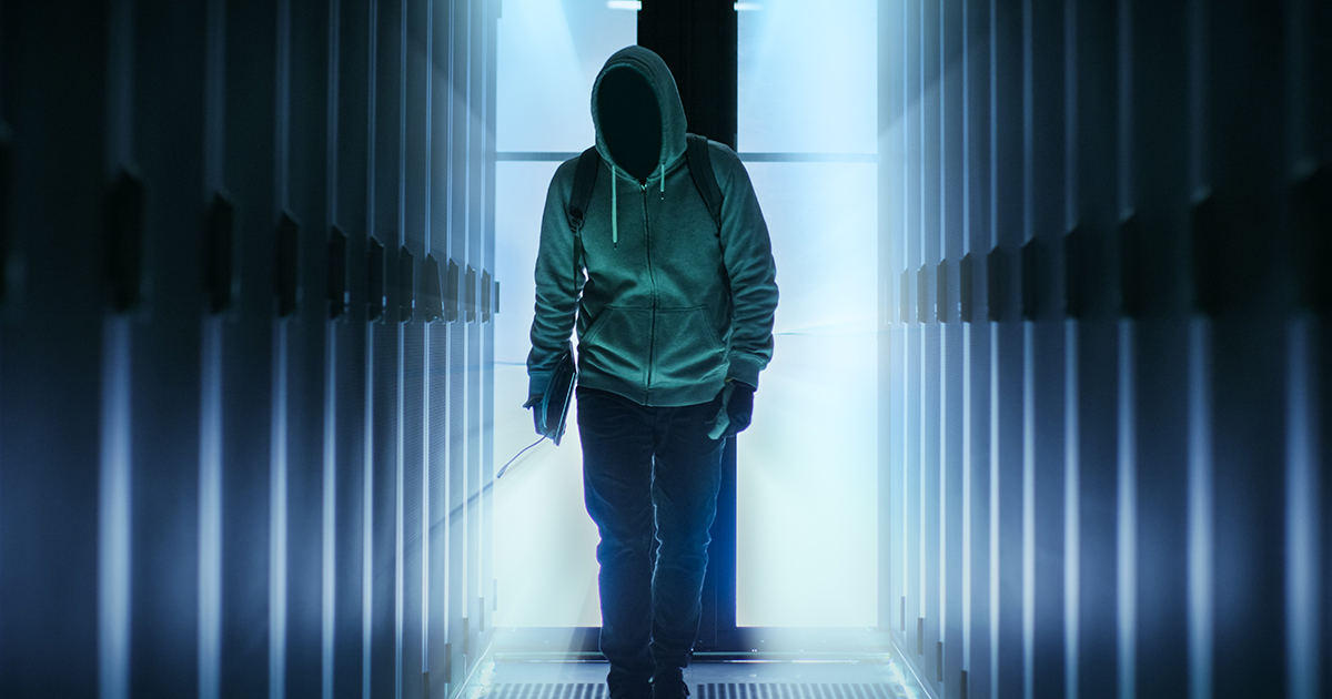 Man in a hoodie walking in a dark alley